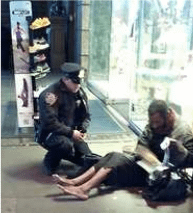 Un policier chaussant un SDF